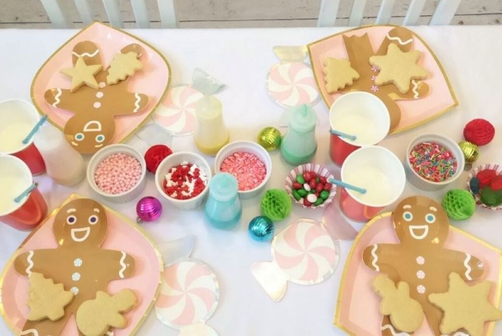 Decorated sugar cookies with baby-themed and Sims 4-inspired patterns arranged on a festive party table