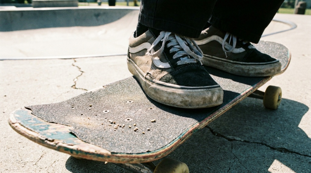 Close-up of shoes standing on a skateboard deck